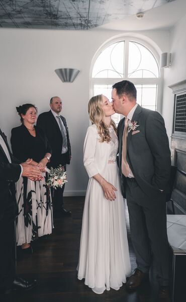 Brautpaar küsst sich nach der standesamtlichen Trauung auf der Vineta im Störmthaler See bei Leipzig