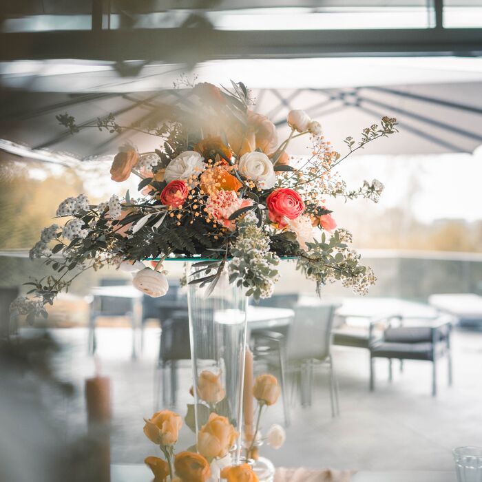 wunderschöne Floristik für eine Hochzeit in der Elblounge in Dresden bestehend aus hohen Vasen und einem üppigem Gesteck