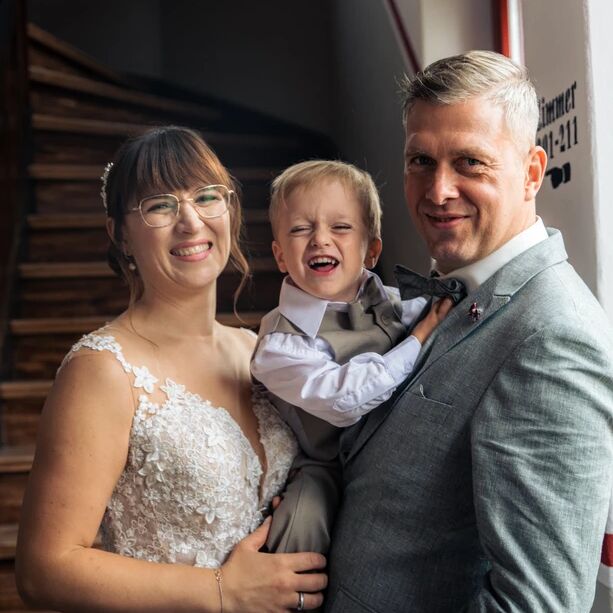 Brautpaar mit Sohn während des Brautpaarshootings zu Ihrer Hochzeit im Waldschlösschen Nebra