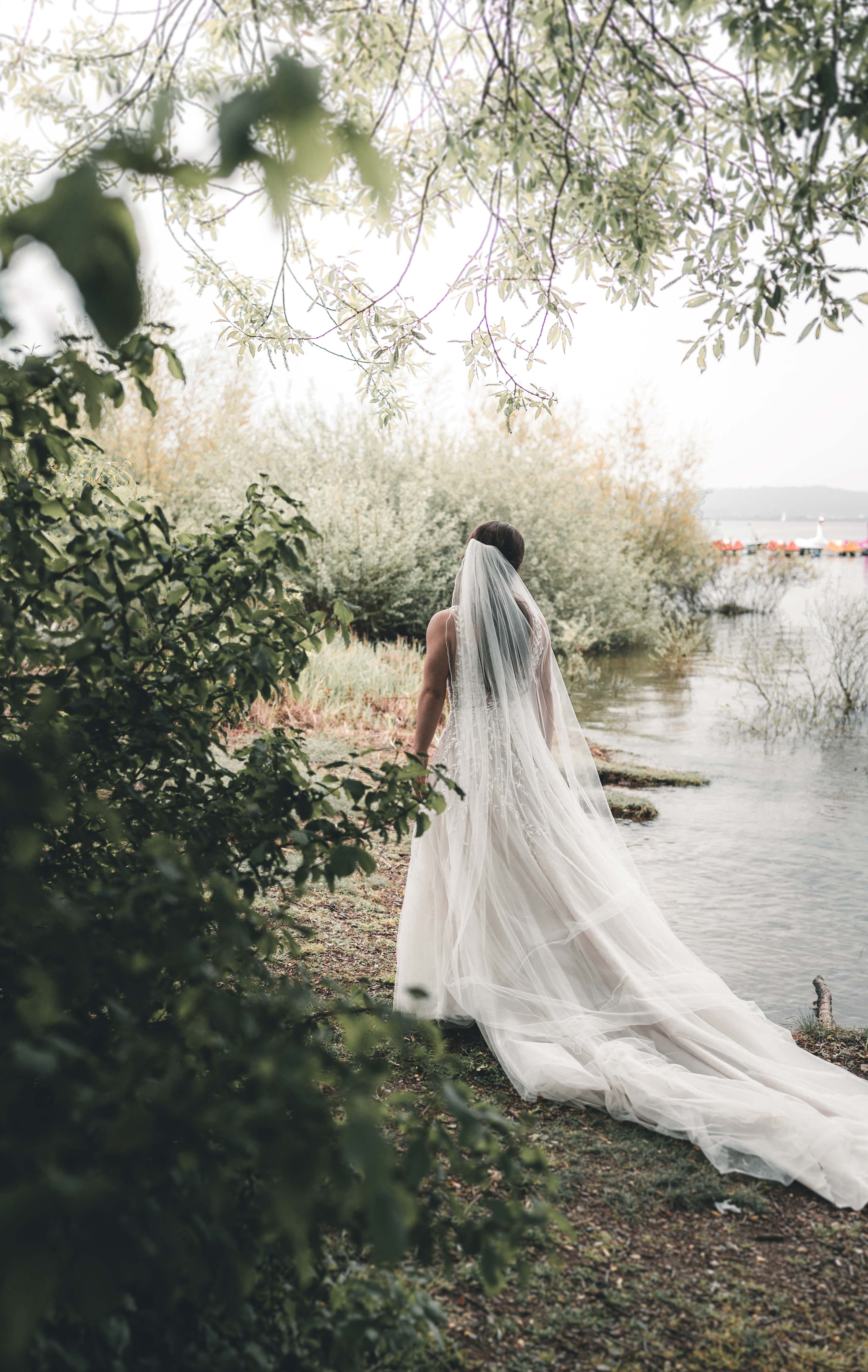 Braut am Ufer des Möhnesees während einer Ganztagesreportage im Sauerland – natürliche Hochzeitsfotografie einer romantischen Hochzeit