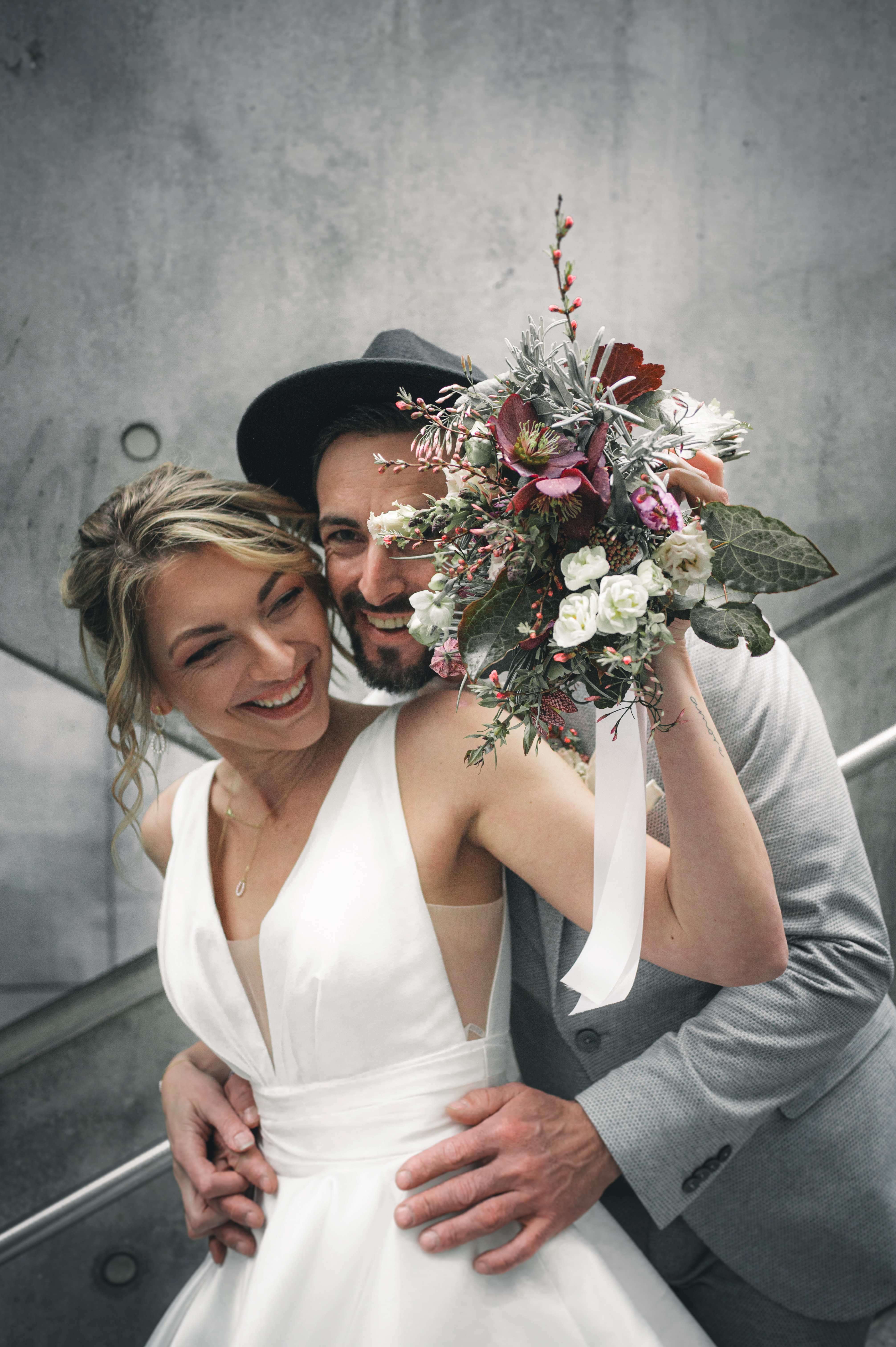 Lachendes Brautpaar beim urbanen Brautpaarshooting am Bayerischen Bahnhof Leipzig – moderne Hochzeitsreportage einer Stadthochzeit