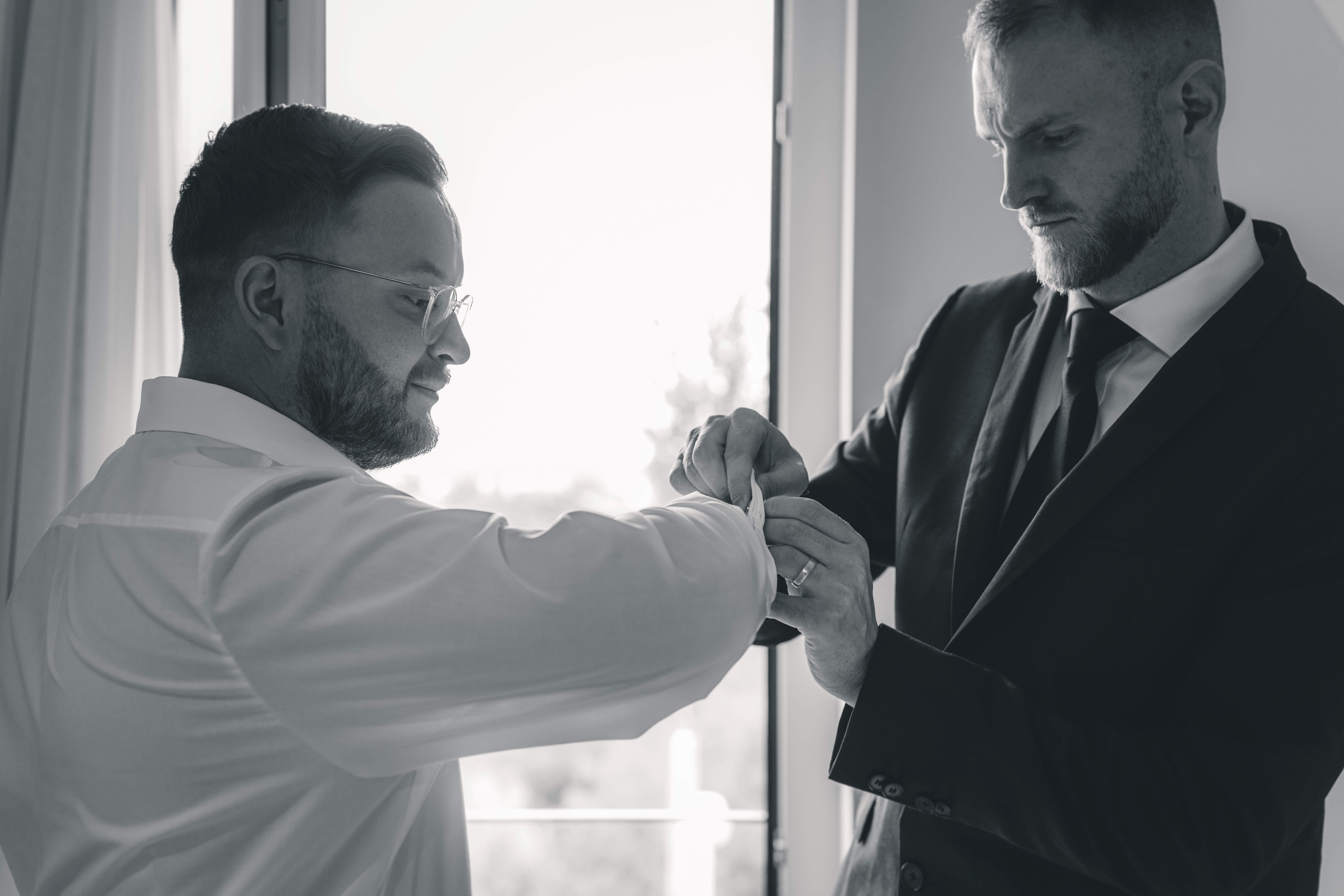 Bräutigam beim Getting Ready mit seinem Trauzeugen am Fenster – authentischer Moment einer Hochzeitsreportage in Dresden