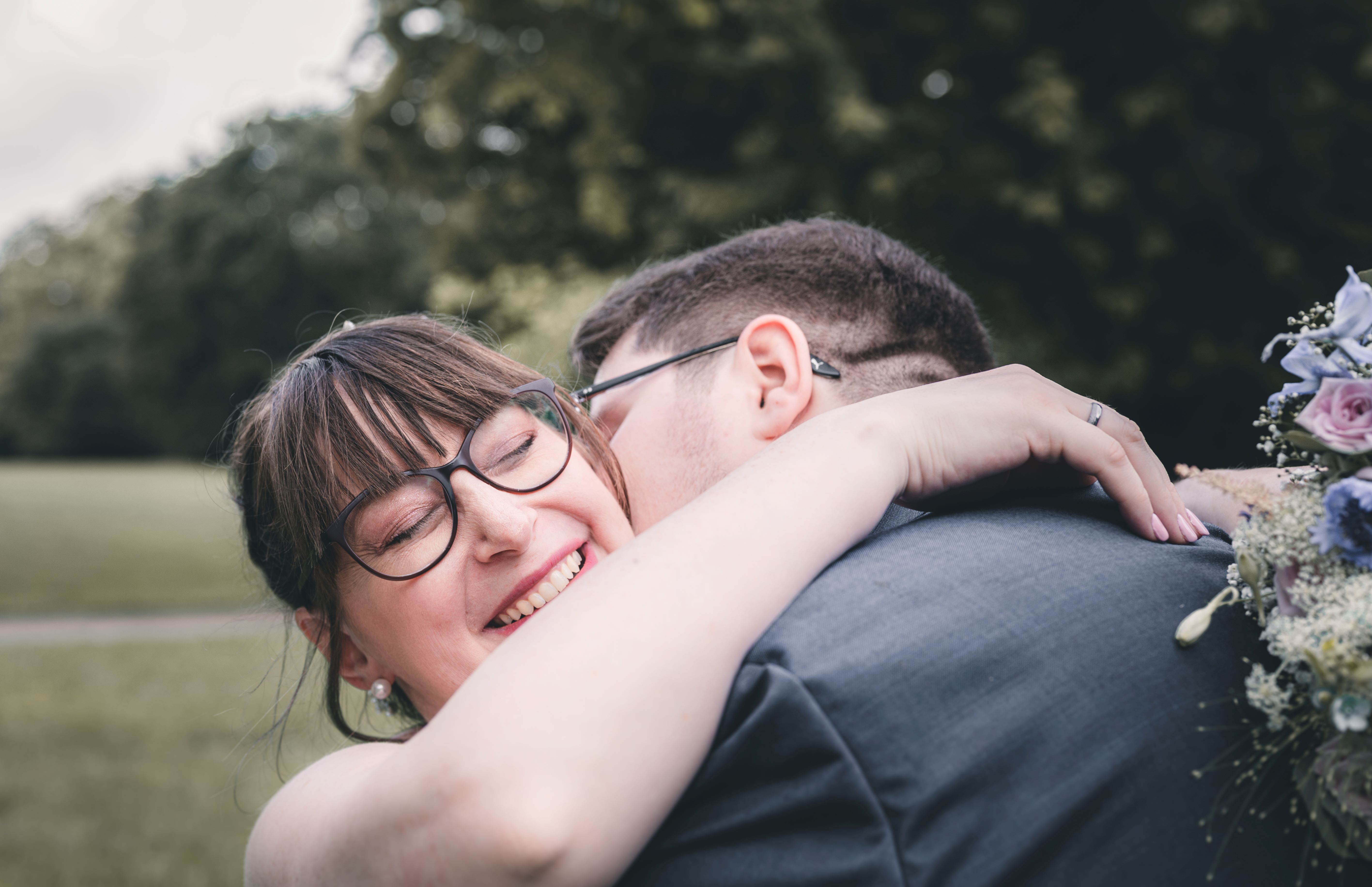 Lachendes Brautpaar beim urbanen Brautpaarshooting im Clara-Zetkin-Park Leipzig – moderne Hochzeitsreportage einer Stadthochzeit