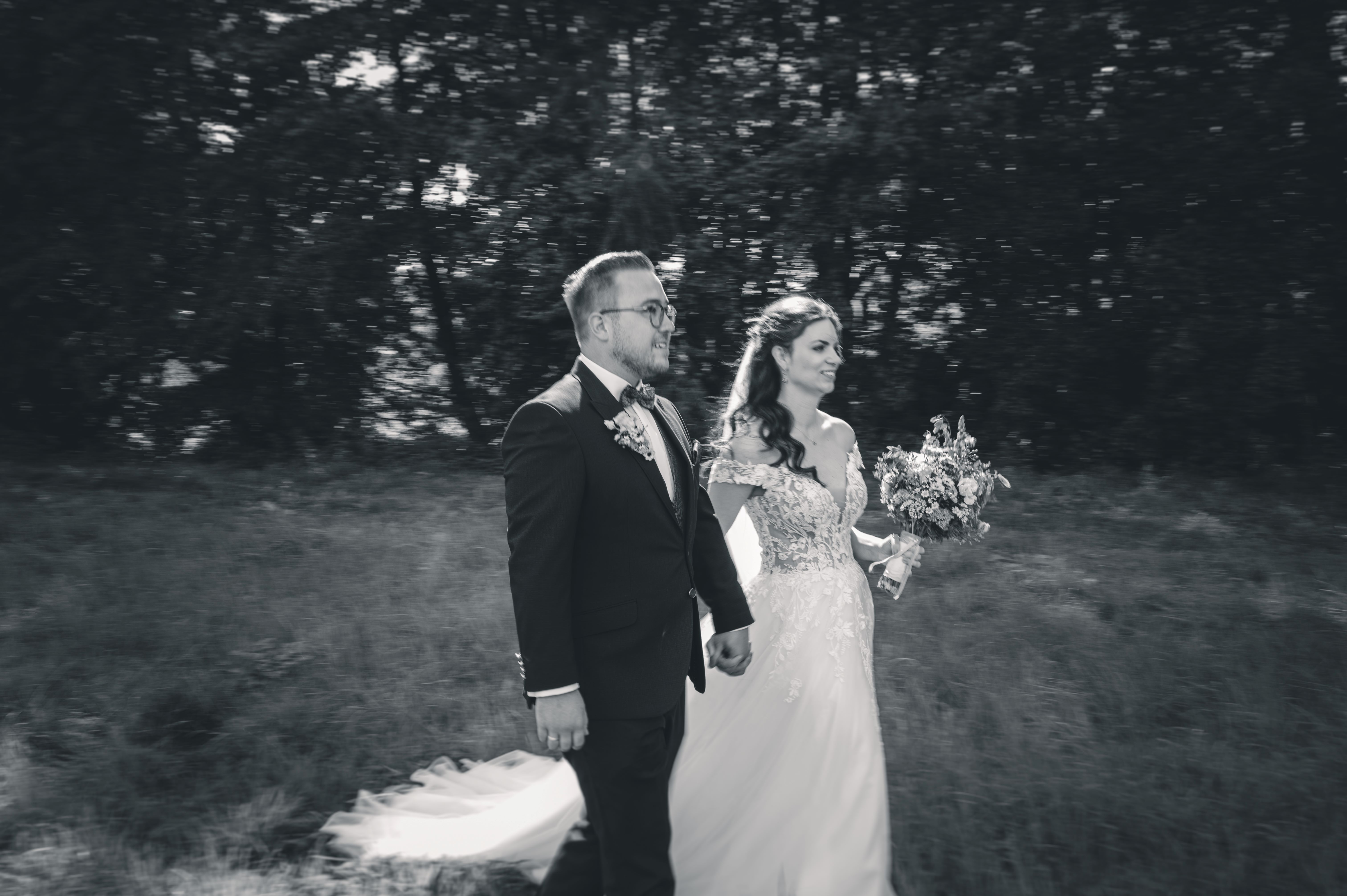 Braut und Bräutigam laufen über ein Feld nach kirchlicher Trauung in Leisnig – emotionale Ganztages-Hochzeitsreportage in Sachsen