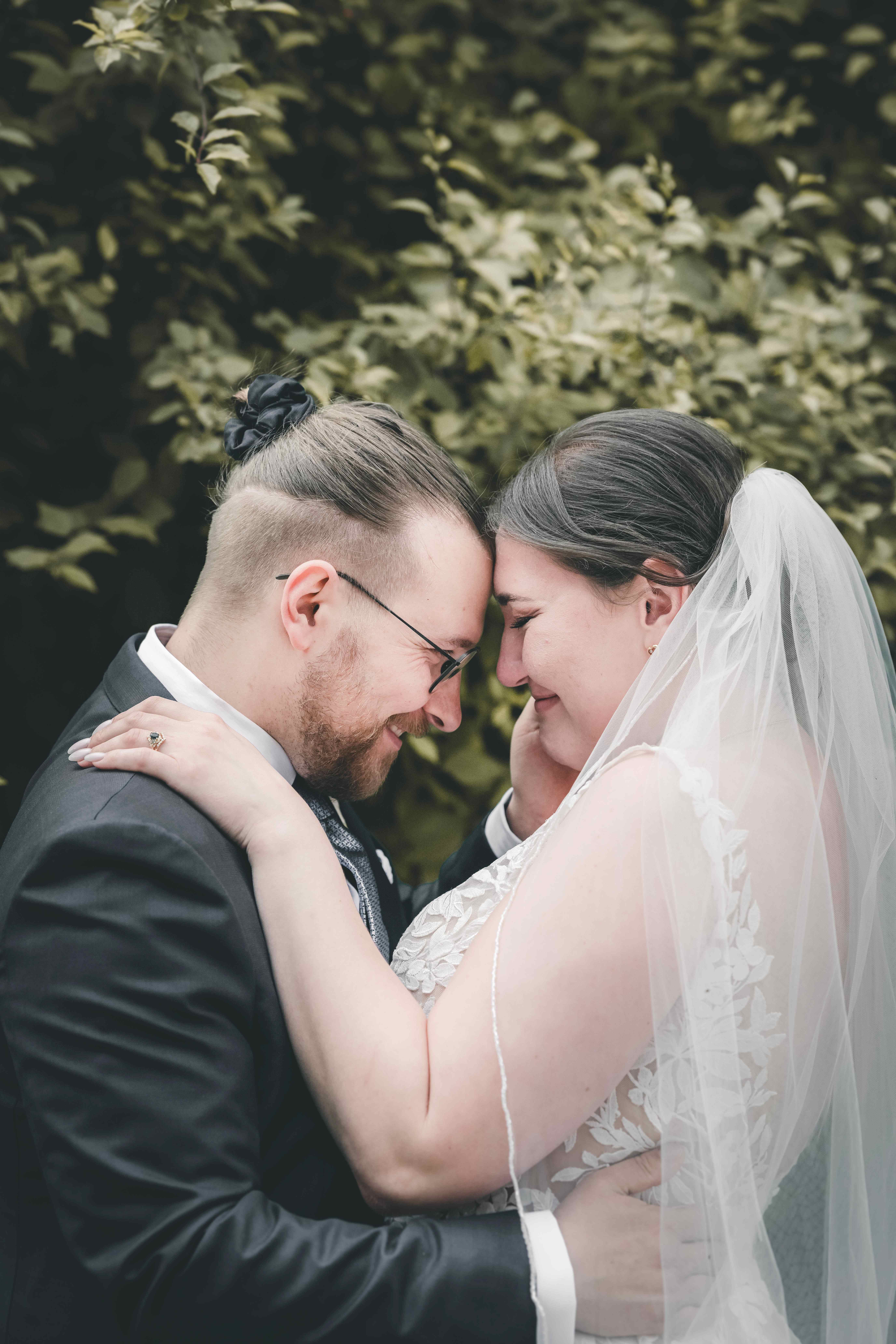 Das Brautpaar schließt mit einem sanften Lächeln die Augen und berührt sich Stirn an Stirn bei der Hochzeitsporträt-Session im Magdalenengut Erfurt.