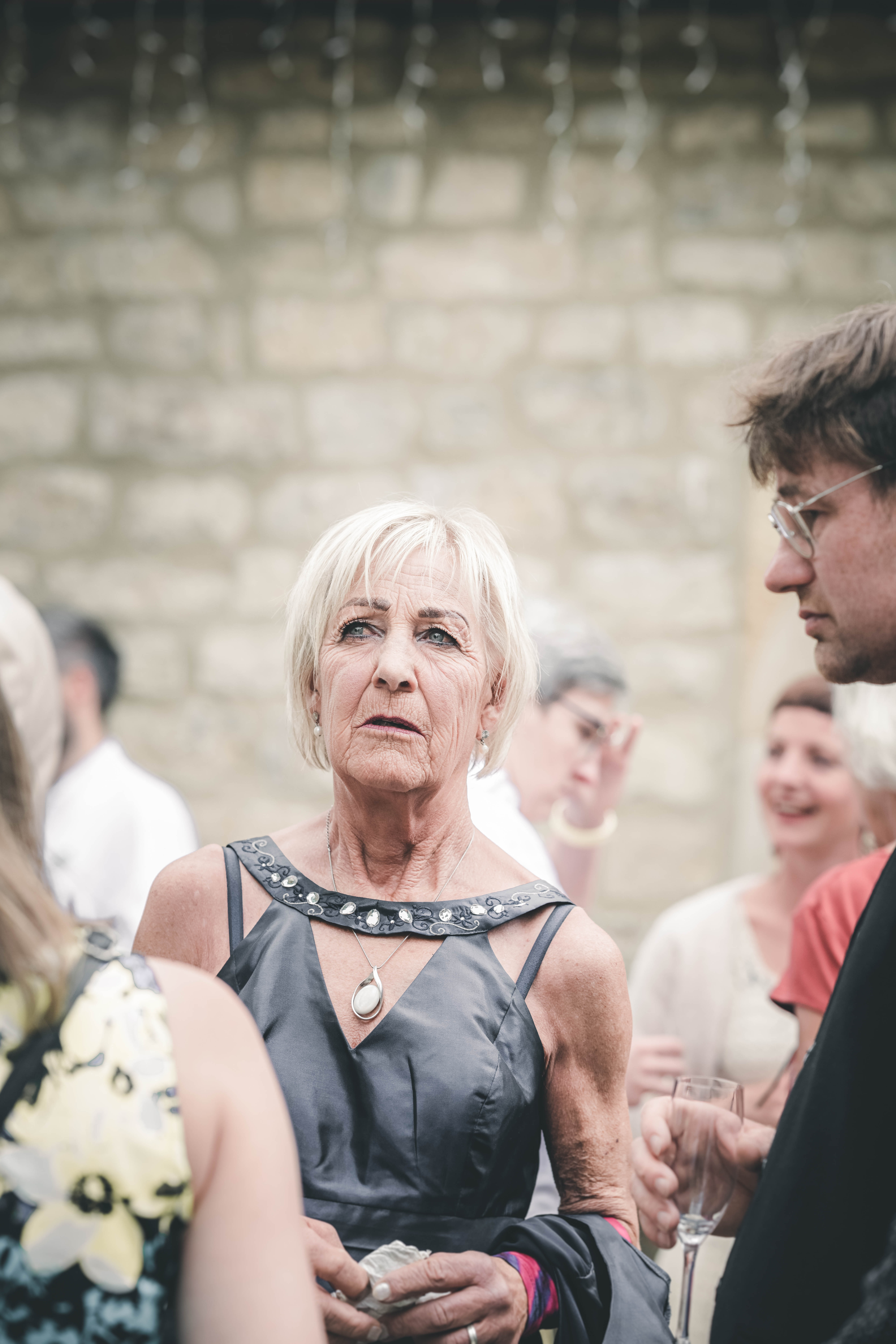 Porträt einer elegant gekleideten Dame im dunkelgrauen Kleid mit Schmucksteinen im Hof des Magdalenenguts Erfurt.