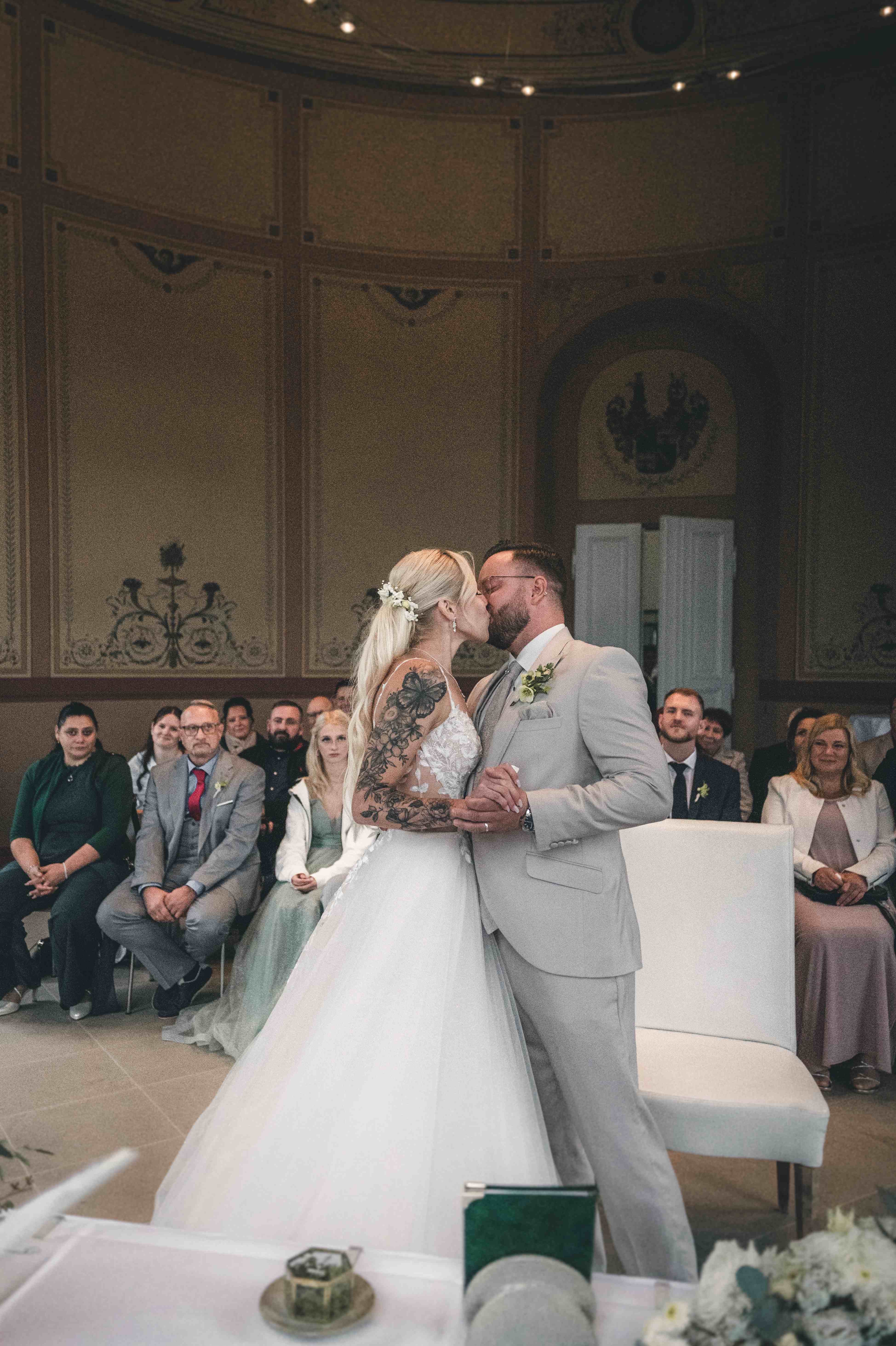 Eine stimmungsvolle Weitwinkel-Aufnahme des Brautpaares beim Hochzeitskuss im prunkvollen, kuppelförmigen Hochzeitssaal in Radebeul.
