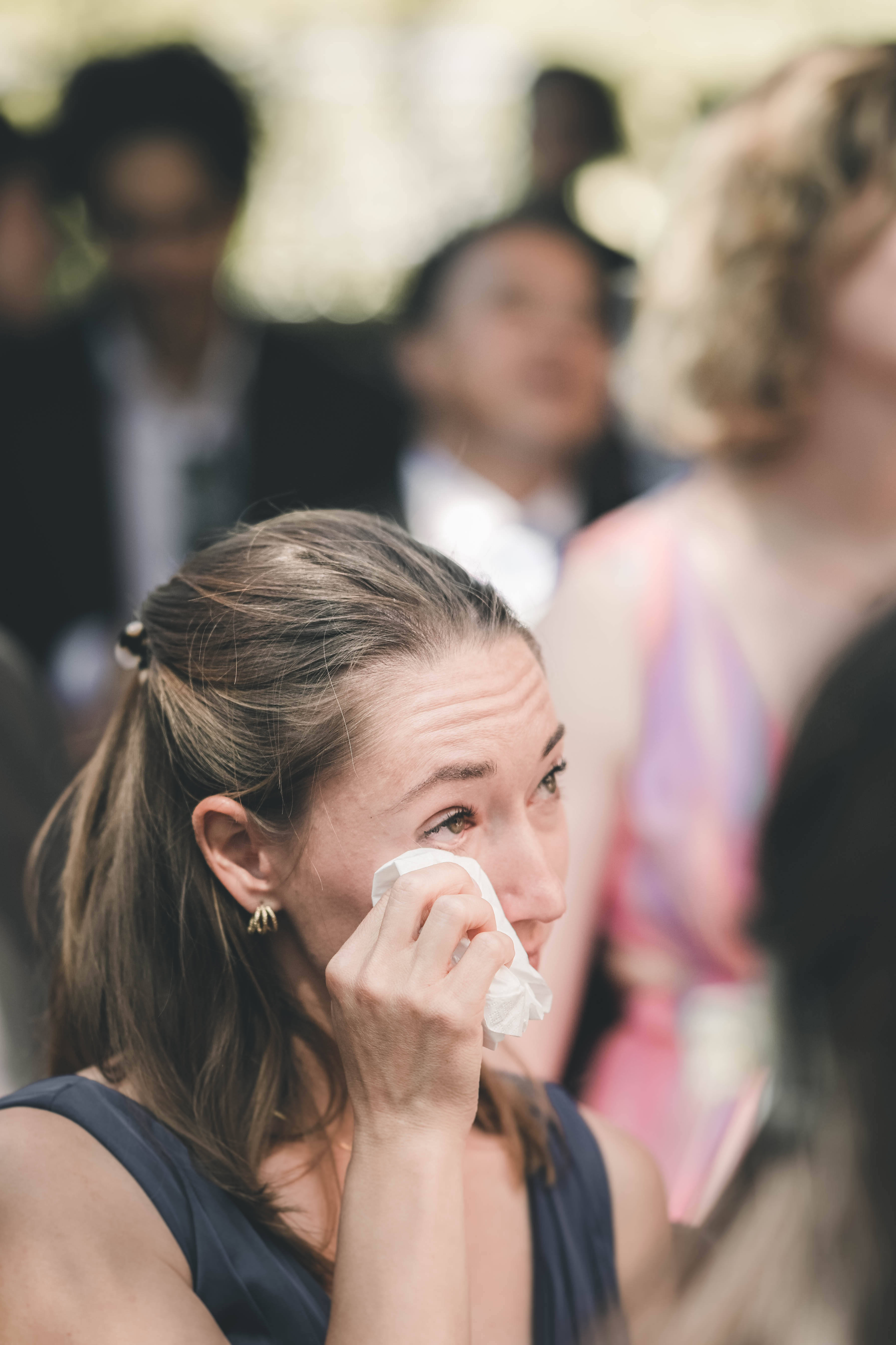Eine Hochzeitsgästin tupft sich während der emotionalen Trauzeremonie im Mörtelwerk Leipzig gerührt eine Träne mit einem Taschentuch ab.