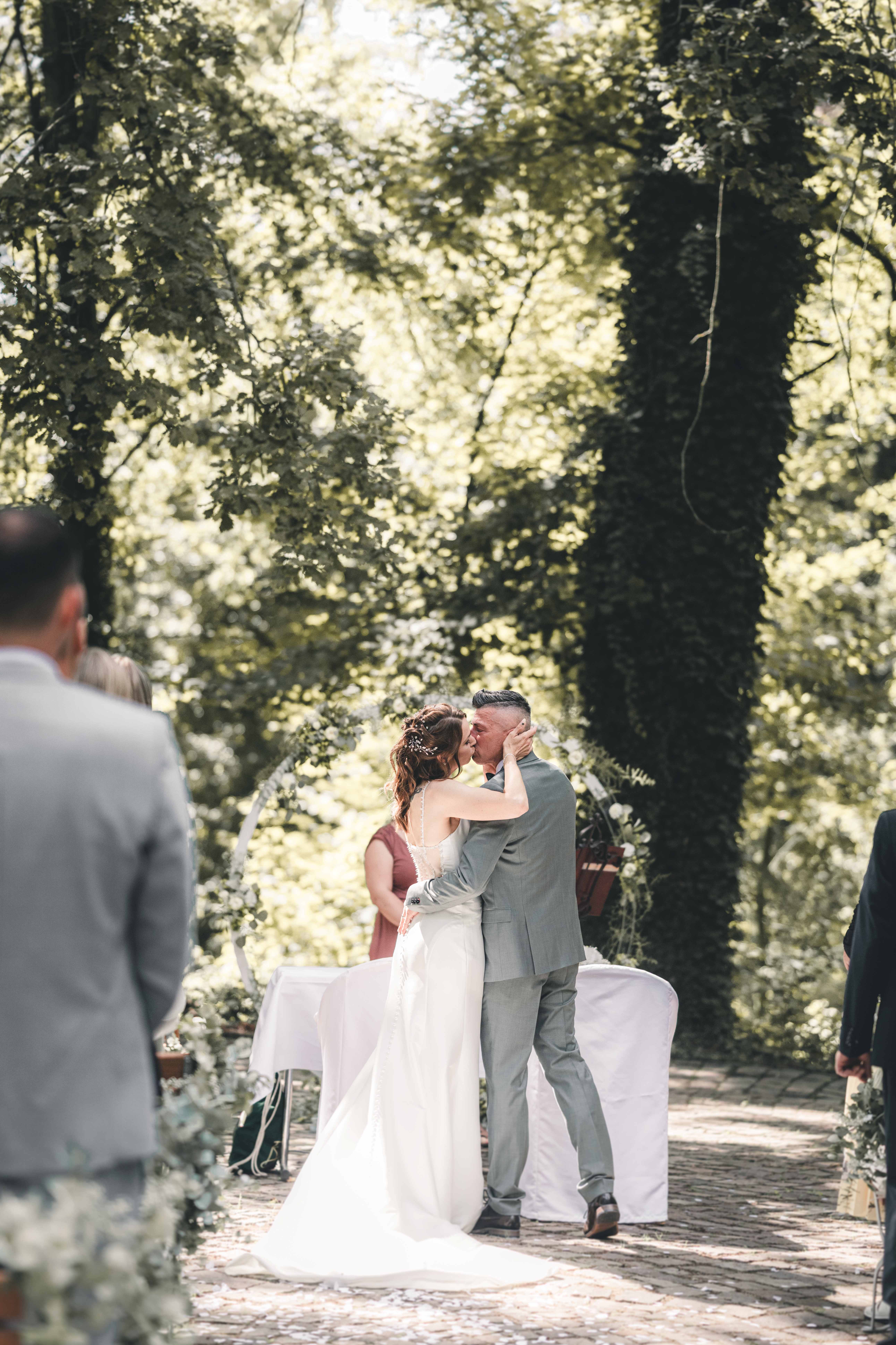 Bride and groom kissing during an outdoor wedding ceremony near Schiffsmühle Grimma – emotional wedding reportage in Saxony, Germany